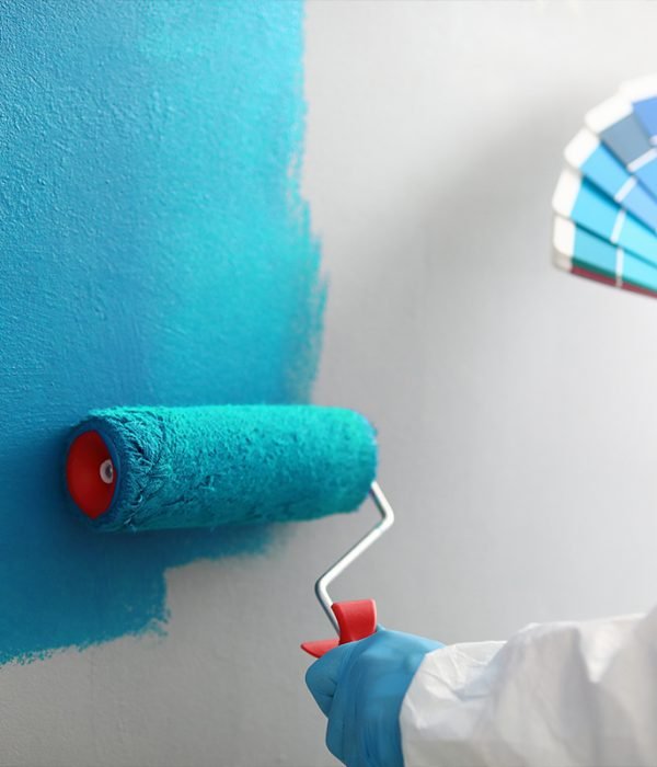 selective focus of handsome handyman touching helmet while holdi